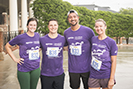 four friends smiling at finish of a 5K