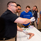 students watch as a doctor demonstrates sutures