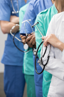 partial view of medical team with arms crossed.