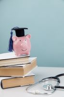 piggy bank in graduation cap, stethoscope