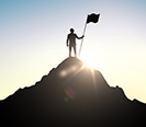 man stands on hill with flag